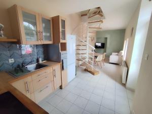a kitchen with a sink and a spiral staircase at La petite Amandaise in Saint-Amand-sur-Sèvre