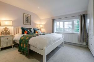 a bedroom with a white bed and a window at The Knutsford Cottage in Knutsford