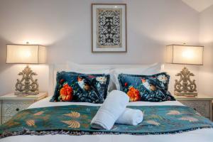 a bed with two pillows and a stuffed animal on it at The Knutsford Cottage in Knutsford