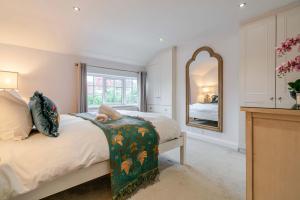 a bedroom with a bed and a large mirror at The Knutsford Cottage in Knutsford