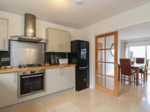 a kitchen with a stove and a table with chairs at Lurach House in Appin