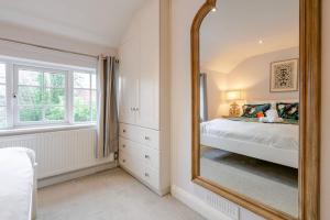 a bedroom with a large mirror and a bed at The Knutsford Cottage in Knutsford +22 photos
