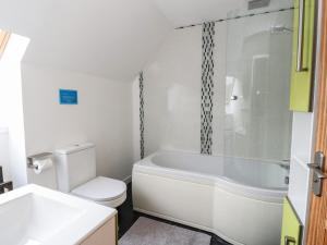 a bathroom with a tub and a toilet and a sink at Lurach House in Appin +18 photos