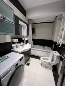 a bathroom with a toilet and a sink and a tub at Central View Prishtina in Prishtinë