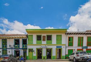 a colorful building with cars parked in front of it at La Posada de la Plaza in Salento