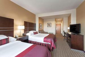 a hotel room with two beds and a flat screen tv at Hotel Willowbrook in Houston