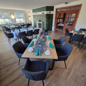 a dining room with a long table and chairs at Die Grenzburg in Güstrow
