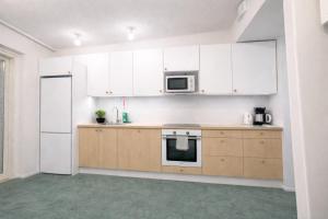 an empty kitchen with white cabinets and a microwave at City Heaven in Turku +3 photos