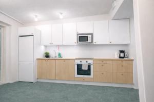 an empty kitchen with white cabinets and a microwave at City Heaven in Turku