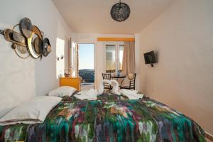 a bedroom with a large bed with a colorful bedspread at Irini Studios in Psarou