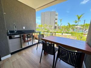 a kitchen with a table and chairs and a sink at Flat Lindo em Muro Alto Resort Beach Class Verano Porto de Galinhas in Porto De Galinhas