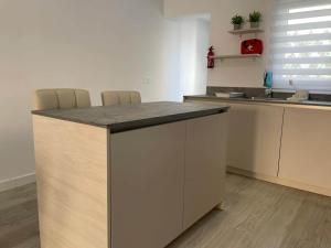 a kitchen with a counter with chairs and a sink at Modern Apartment Near Golf, Beach & Marina in San Pedro del Pinatar