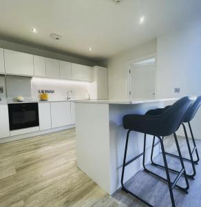 a kitchen with a black stool sitting at a counter at Manor Brook House in Adare