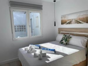 a white bedroom with a bed with towels on it at Modern Apartment Near Golf, Beach & Marina in San Pedro del Pinatar