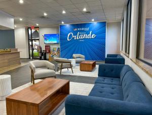 a waiting room with blue couches and a sign on a wall at Hotel Monreale Express & Studios IDrive District in Orlando
