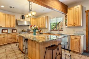 a kitchen with wooden cabinets and a large island with stools at Slot Canyons Inn Bed & Breakfast in Escalante