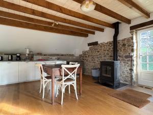 a kitchen with a table and a wood stove at Le petit Valet in Saint-Clément