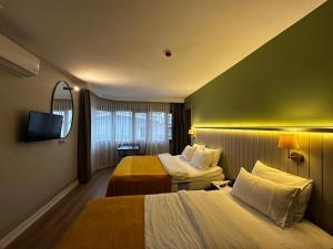 a hotel room with two beds and a tv at OTTO X Hotel in Kavaklıdere