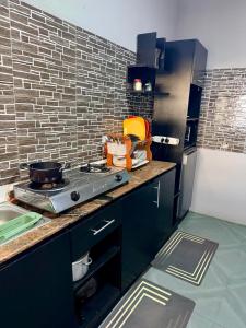 a kitchen with a stove and a brick wall at 3Tee Serviced Apartment Abeokuta in Abeokuta