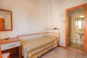 a small bedroom with a bed and a sink at Hotel Happy in Milano Marittima +99 photos