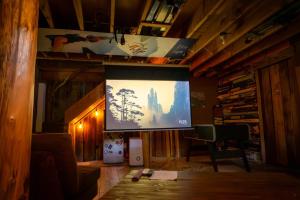 a living room with a large screen in a house at Llama House ADK in Wevertown