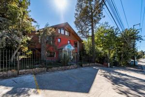 a red house with a fence in front of it at Mirando al Sur in San Carlos de Bariloche