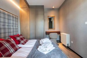a bedroom with a bed with red pillows and a desk at Gerlach in Zakopane +36 photos