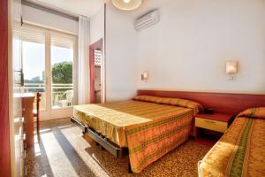 a bedroom with two beds and a window at Hotel Happy in Milano Marittima