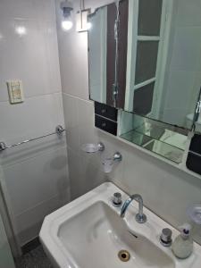 a white bathroom with a sink and a mirror at Encanto en el centro salteño in Salta