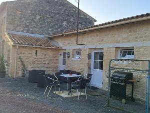 a table and chairs in front of a building at Chez Mamisa in Saint-Mandé-sur-Brédoire