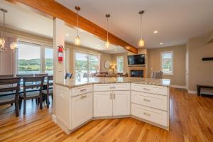 a kitchen with white cabinets and a dining room at Apres Ski by Railey Vacations in McHenry
