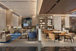 a restaurant with tables and chairs and a lobby at Petaling Jaya Marriott Hotel in Petaling Jaya