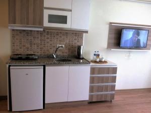 cocina con fregadero y TV en la pared en Bayrambey Residence Eskisehir, en Eskisehir