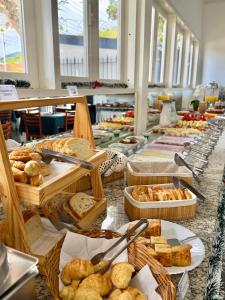 a buffet line with different types of bread and pastries at Hotel Arrastão in São Sebastião +49 photos