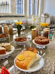 a table topped with plates of cakes and pastries at Hotel Arrastão in São Sebastião