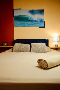 a bed with two pillows and a painting on the wall at Panama Beach Lodge in San Carlos