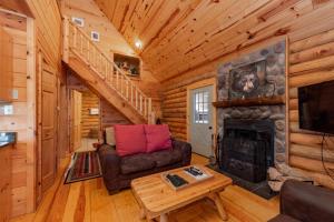 a living room with a fireplace in a log cabin at Tree Haus by Railey Vacations in Oakland