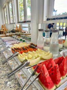 a buffet line with fruits and vegetables on plates at Hotel Arrastão in São Sebastião