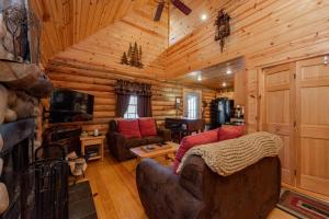a living room with a couch and a television in a log cabin at Tree Haus by Railey Vacations in Oakland