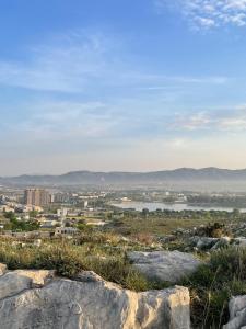 a view of a city from a hill with rocks at Own It Hotel in Islamabad