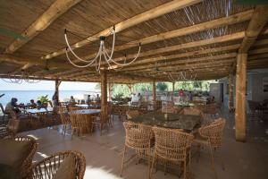 a restaurant with tables and chairs and the ocean at Enjoy Lichnos Bay Village, Camping, Hotel and Apartments in Parga