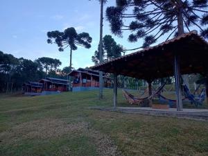 a tent with hammocks in a park with houses at Pousada Anabela in Campo Alegre