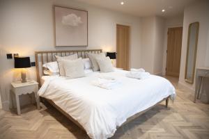 a bedroom with a large bed with white sheets and pillows at Highland House in Lochearnhead