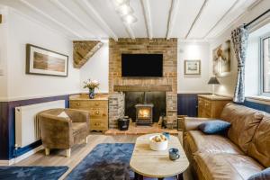 a living room with a couch and a fireplace at 2 Bed in Wickhampton oc-t34449 in Wickhampton