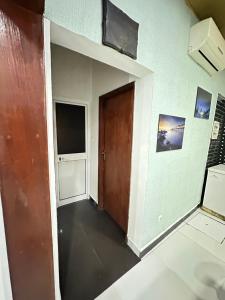 an empty room with a door and a television at Nara Cíntia in Luanda