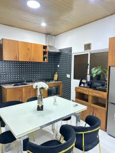 a kitchen with a white table and blue chairs at Nara Cíntia in Luanda