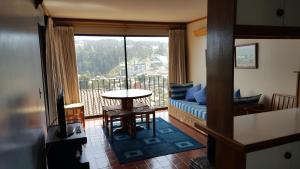 a living room with a balcony with a table and a couch at Fortezuelo - Colina IV in Viña del Mar