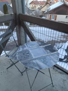 a glass table and a chair on a balcony at 265 rue du clos capperony in Les Rousses