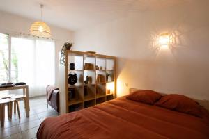 a bedroom with a bed and a table and a window at La cabanne aux bambous in Villenave-dʼOrnon