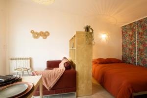 a bedroom with a bed and a couch and a table at La cabanne aux bambous in Villenave-dʼOrnon